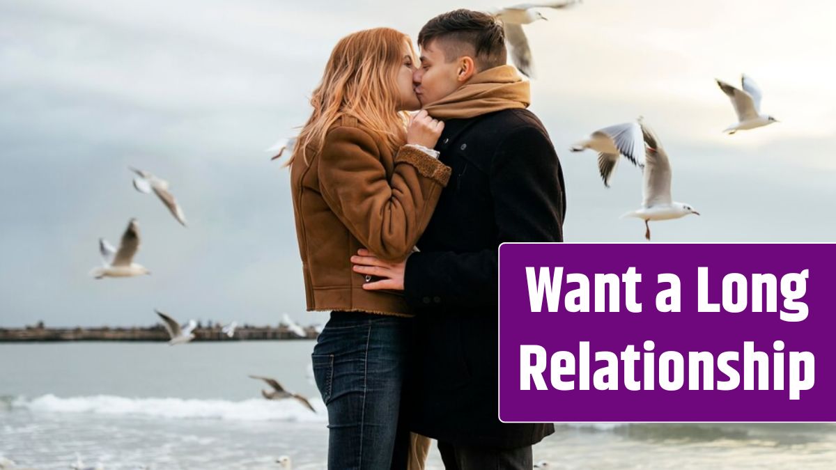 Side view of young couple in winter by the beach.